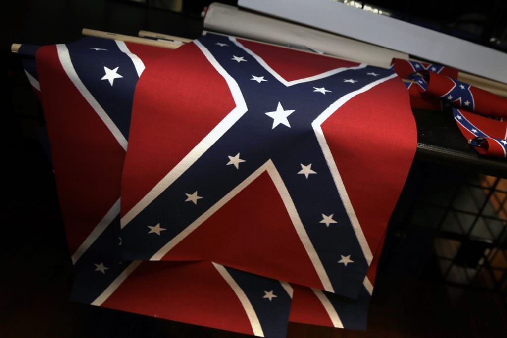 Small Confederate flags are displayed on a shelf at Arkansas Flag and Banner in Little Rock, Ark., Tuesday, June 23, 2015. Major retailers including Amazon, Sears, eBay and Etsy and Wal-Mart Stores Inc., are halting sales of the Confederate flag and related merchandise. (AP Photo/Danny Johnston)